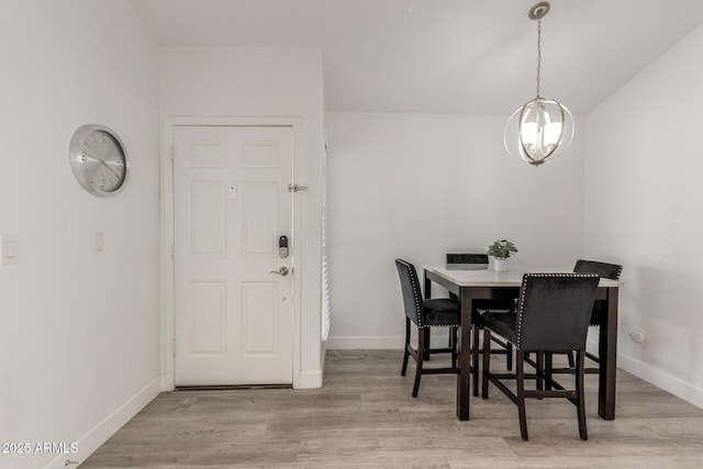 dining space with an inviting chandelier, wood finished floors, and baseboards