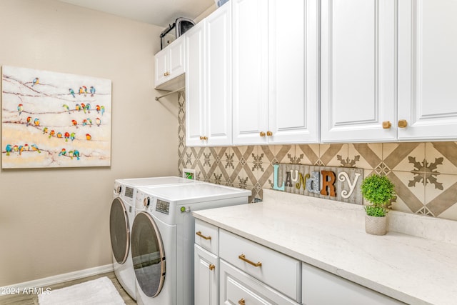 laundry room with separate washer and dryer and cabinets