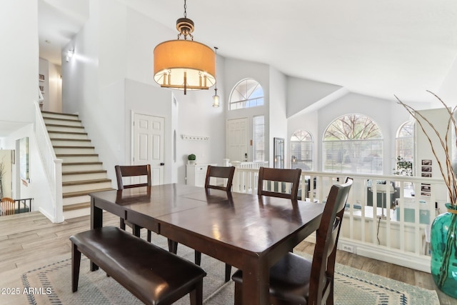 dining room with hardwood / wood-style flooring and high vaulted ceiling