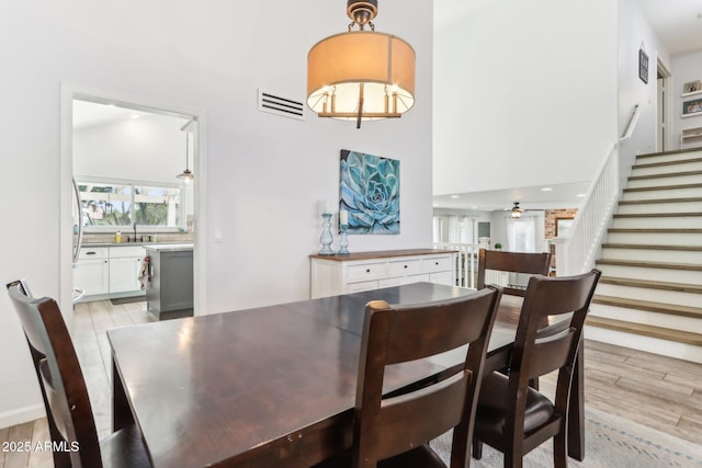 dining area featuring ceiling fan, sink, and light hardwood / wood-style floors