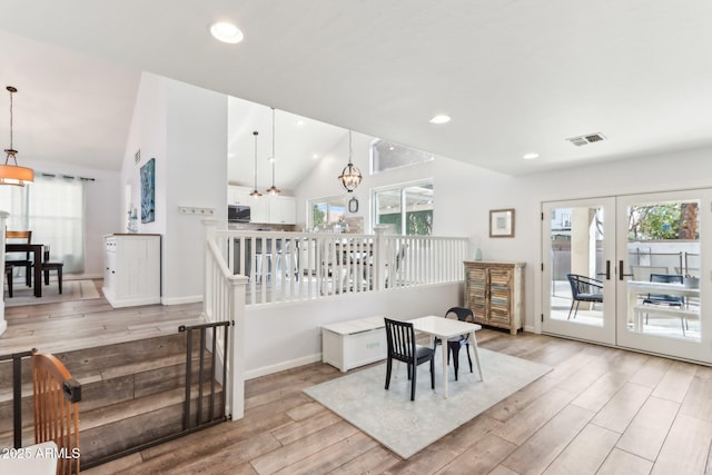 interior space with a healthy amount of sunlight, a chandelier, and light hardwood / wood-style flooring