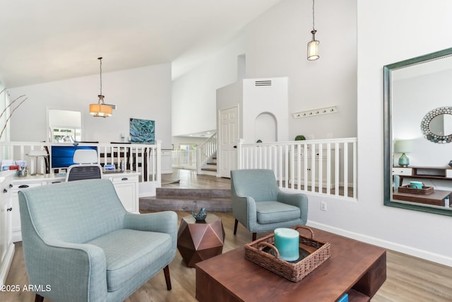 sitting room with high vaulted ceiling and light wood-type flooring