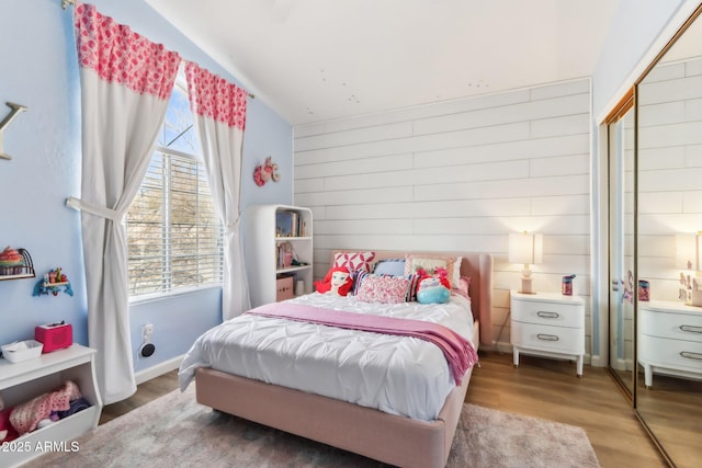 bedroom with hardwood / wood-style floors and wooden walls