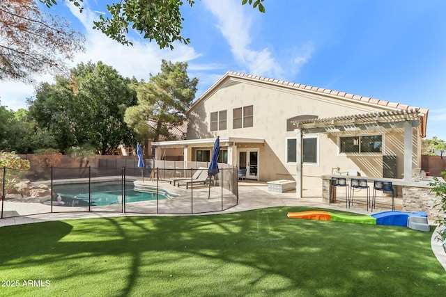 back of house featuring a fenced in pool, a pergola, a patio area, and a yard