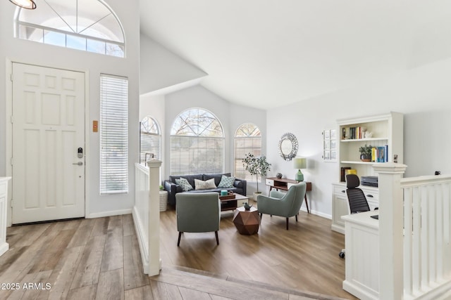 entryway with high vaulted ceiling and light wood-type flooring