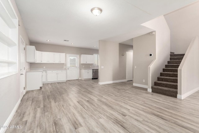 unfurnished living room with light wood-type flooring, stairway, and baseboards