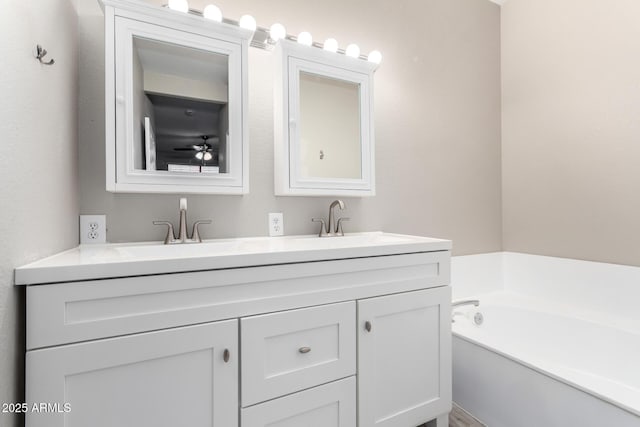 full bath with a garden tub, double vanity, and a sink