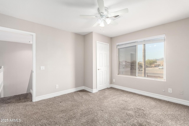 unfurnished room featuring carpet floors, baseboards, and a ceiling fan