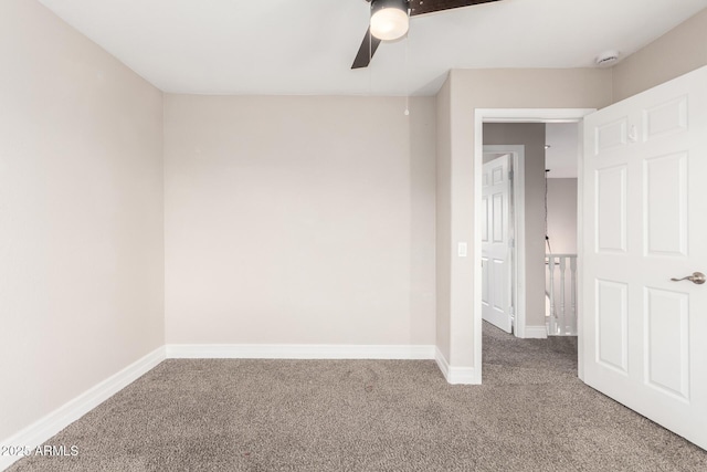 carpeted spare room with ceiling fan and baseboards