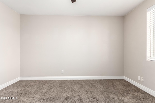 carpeted spare room featuring baseboards