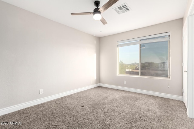 empty room with ceiling fan, carpet flooring, visible vents, and baseboards