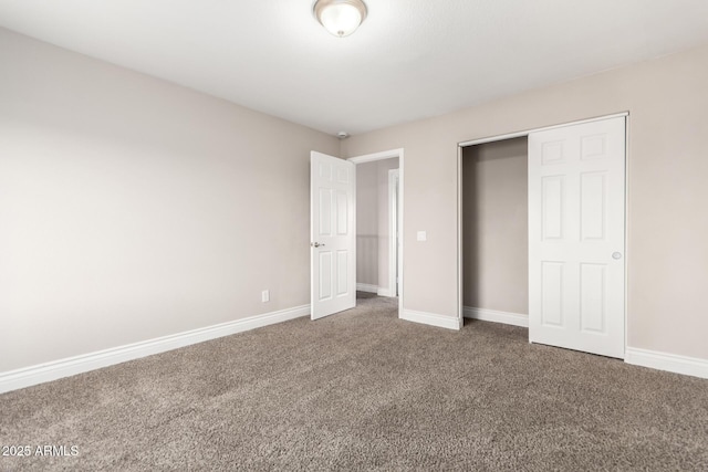 unfurnished bedroom with a closet, carpet flooring, and baseboards