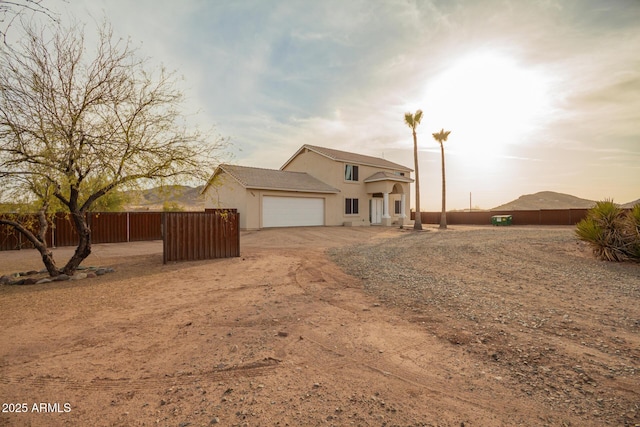 view of front of property with an attached garage, fence, and stucco siding