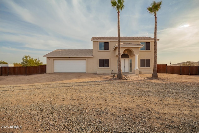 view of front of home featuring a tile roof, fence, an attached garage, and stucco siding