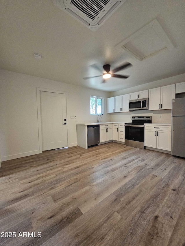 kitchen with light countertops, appliances with stainless steel finishes, visible vents, and light wood-style floors