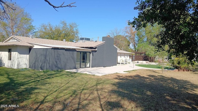 back of house with a yard, a chimney, a patio area, and fence