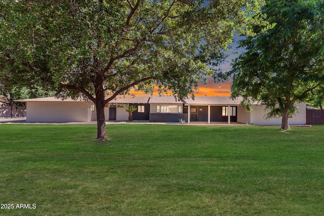 2425 E Harvard St, Phoenix, AZ 85008 - back of house at dusk featuring a yard and stucco siding