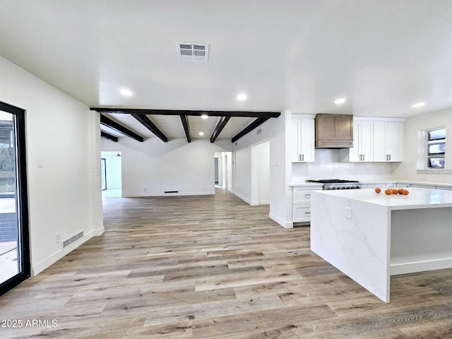 kitchen with light countertops, open floor plan, visible vents, and white cabinets