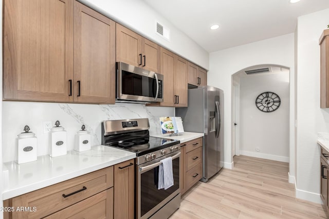 955 E Knox Rd Unit 126, Chandler, AZ 85225 - kitchen with stainless steel appliances, arched walkways, light wood-type flooring, recessed lighting, and backsplash