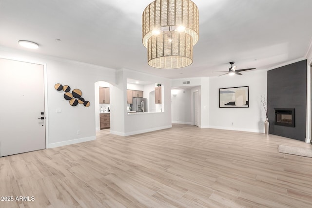 955 E Knox Rd Unit 126, Chandler, AZ 85225 - unfurnished living room featuring ornamental molding, arched walkways, a fireplace, ceiling fan, and light wood-style floors