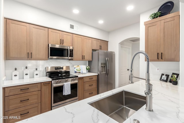 955 E Knox Rd Unit 126, Chandler, AZ 85225 - kitchen with stainless steel appliances, light stone counters, arched walkways, and recessed lighting