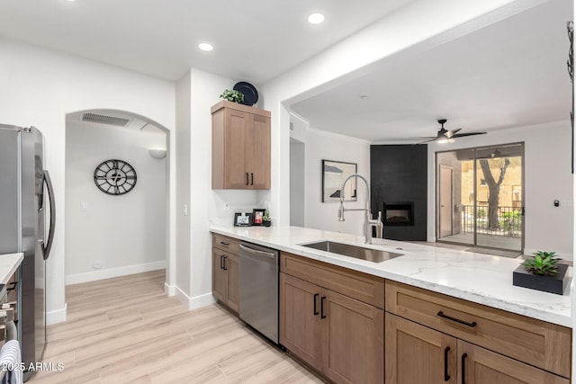 955 E Knox Rd Unit 126, Chandler, AZ 85225 - kitchen with stainless steel appliances, a ceiling fan, light stone countertops, arched walkways, and light wood-style flooring