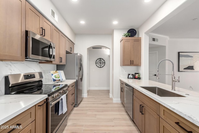 955 E Knox Rd Unit 126, Chandler, AZ 85225 - kitchen featuring stainless steel appliances, arched walkways, light stone countertops, recessed lighting, and light wood-type flooring