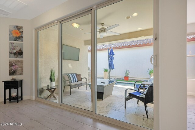 doorway to outside with light wood-type flooring and ceiling fan