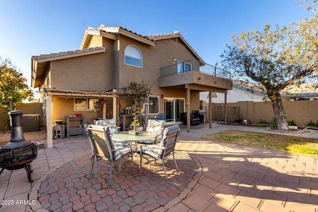 rear view of house with a balcony, a patio, and central AC unit