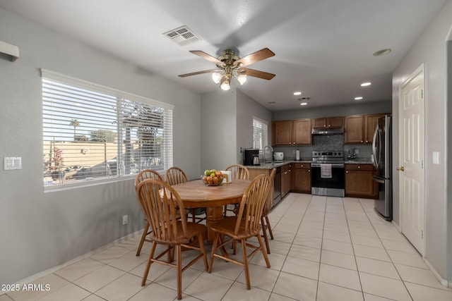 tiled dining room with sink and ceiling fan