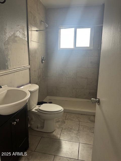 bathroom with vanity, toilet, a shower stall, and tile patterned floors