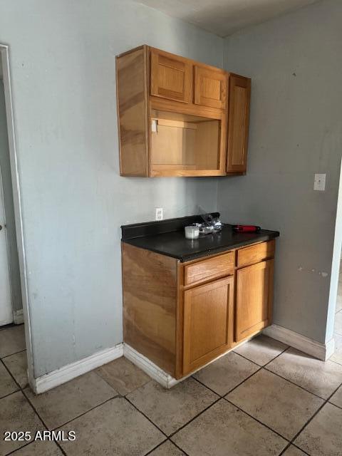 bar area with baseboards and light tile patterned floors