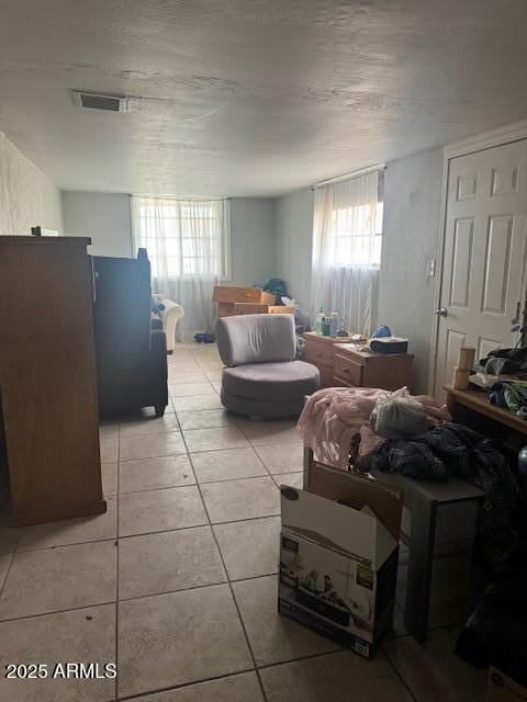 bedroom with light tile patterned floors and multiple windows