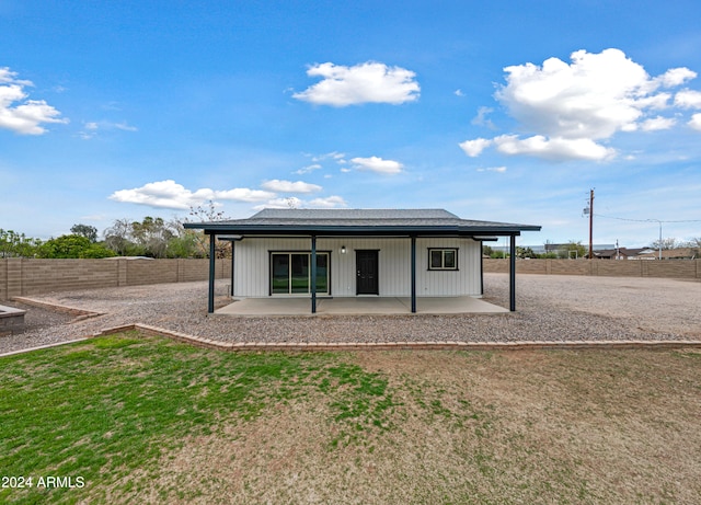 rear view of house featuring a patio area and a lawn