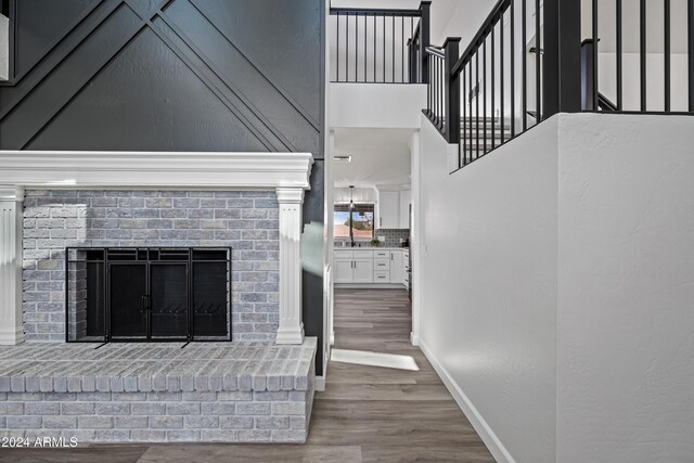 394 E Redfield Rd, Chandler, AZ 85225 - unfurnished living room featuring wood finished floors, a fireplace, baseboards, a towering ceiling, and a sink
