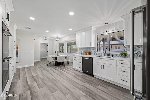 kitchen with appliances with stainless steel finishes, light wood-type flooring, white cabinetry, and sink