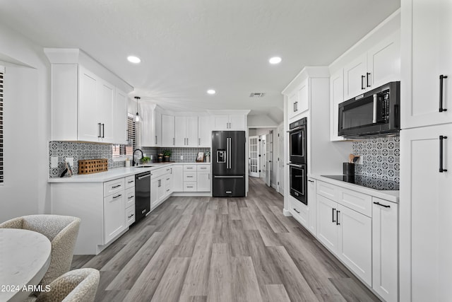 kitchen featuring decorative backsplash, light hardwood / wood-style flooring, white cabinets, and black appliances