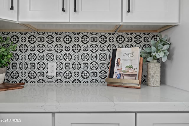 details featuring light stone countertops and white cabinetry