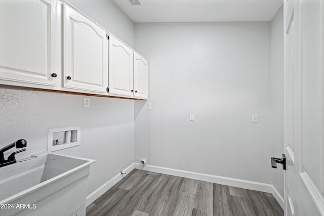 laundry area with cabinets, hookup for a washing machine, hardwood / wood-style flooring, and sink