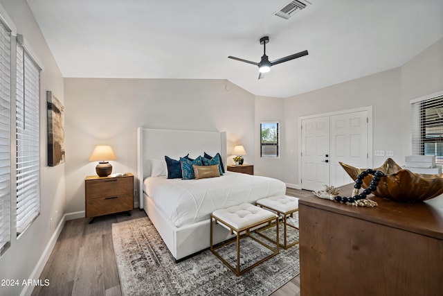 bedroom with ceiling fan, lofted ceiling, multiple windows, and light hardwood / wood-style flooring