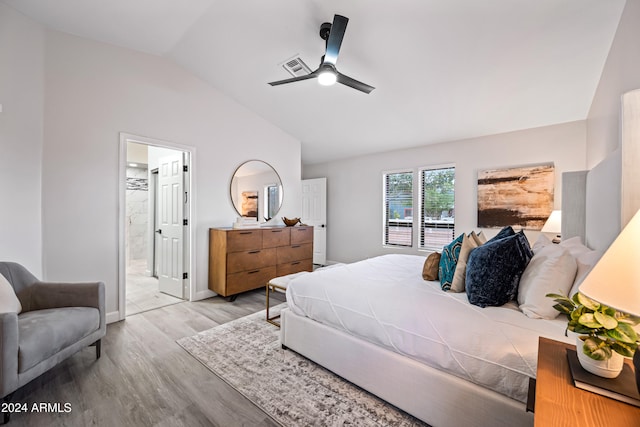 bedroom featuring ensuite bath, ceiling fan, lofted ceiling, and light wood-type flooring