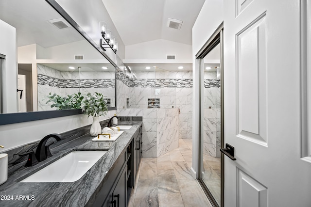 bathroom featuring vanity, tiled shower, and vaulted ceiling