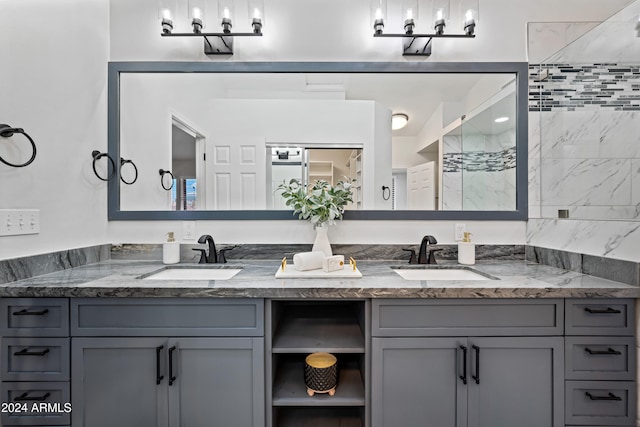 bathroom with a tile shower and vanity