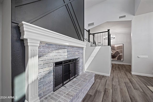 interior details featuring a fireplace, hardwood / wood-style flooring, and an inviting chandelier