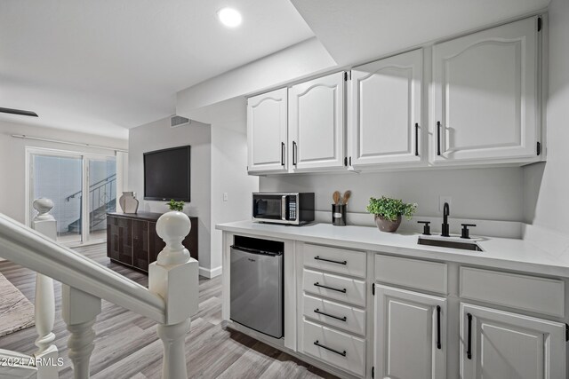 394 E Redfield Rd, Chandler, AZ 85225 - bar area featuring stainless steel microwave, refrigerator, a sink, light wood-type flooring, and baseboards
