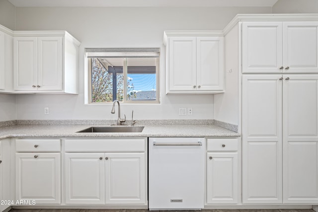 kitchen featuring dishwasher, white cabinets, and sink