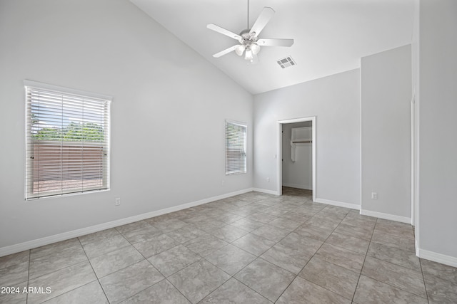 tiled spare room featuring ceiling fan and high vaulted ceiling