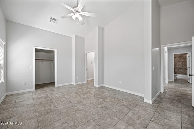 unfurnished bedroom with ceiling fan, high vaulted ceiling, and a closet