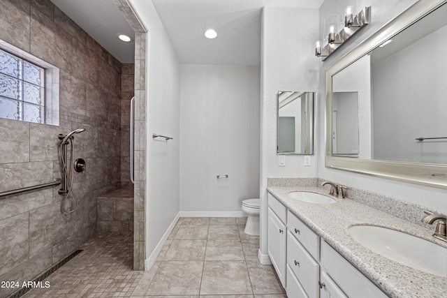 bathroom featuring tiled shower, tile patterned floors, vanity, and toilet