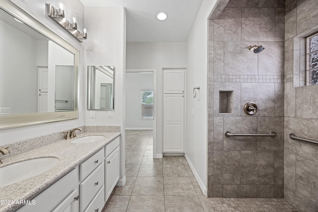 bathroom with tile patterned floors, vanity, and a tile shower